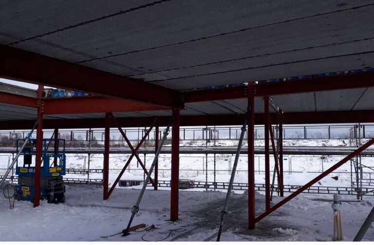 Konstruksjon av ny bygningsramme under bygging i snøfylt område, klar for videre oppføring, fokus på ny nettsideutvikling og profesjonell byggeprosess.