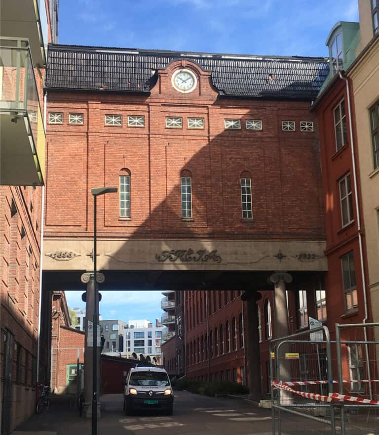 Historisk bygning med arched forbindelse, moderne bymiljø, byggkonsulenter, ny nettside, arkitektur, sentralt beliggende, tilpasset byggprosjekter, byggkonsulenter, bygningsanalyser, nettsideutvikling.